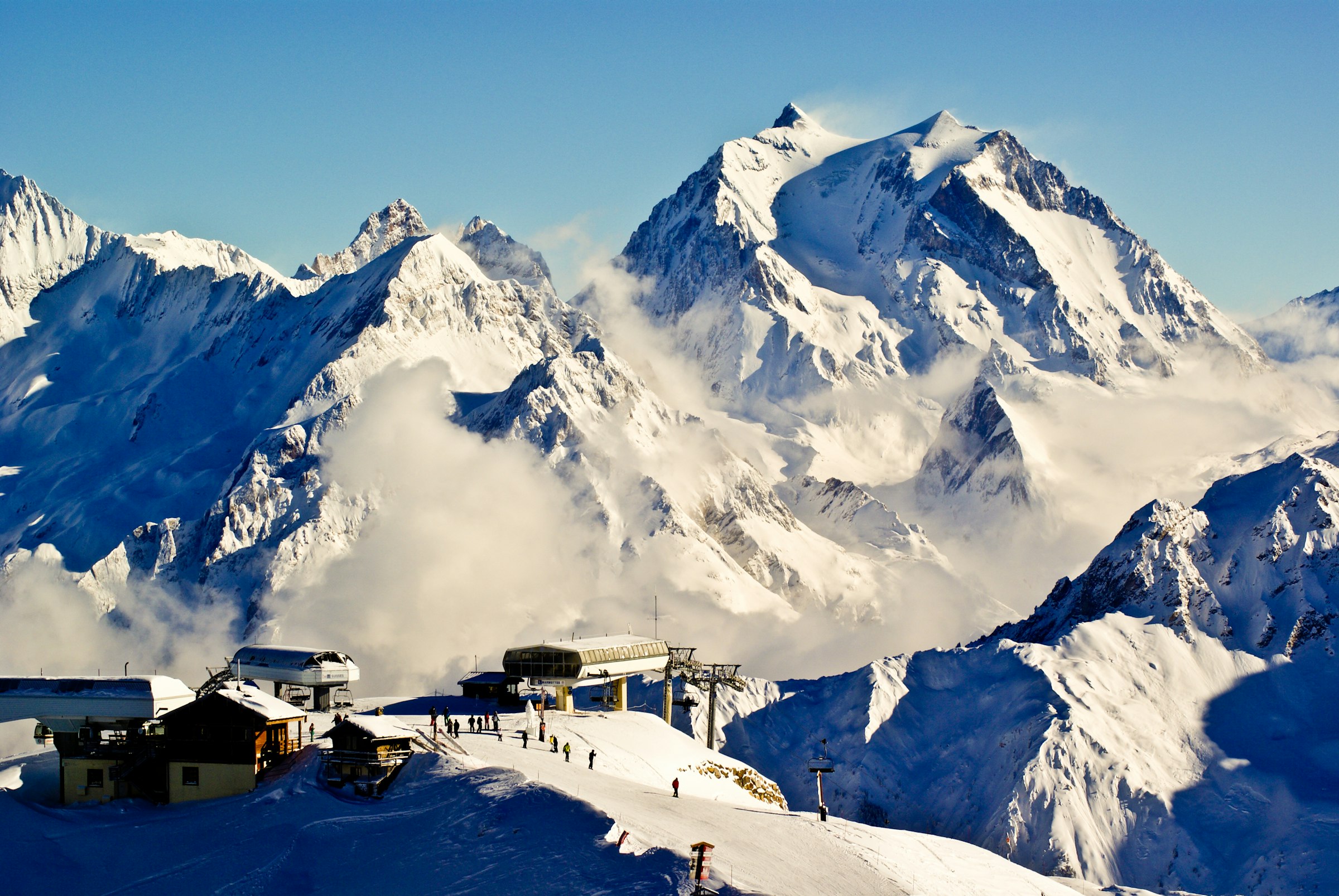 Snow-covered mountain ridge above Courchevel with a ski lift line crossing the slope